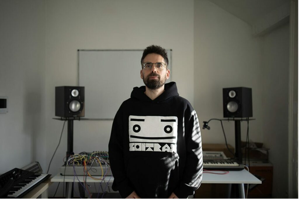 man standing in front of electronic music studio